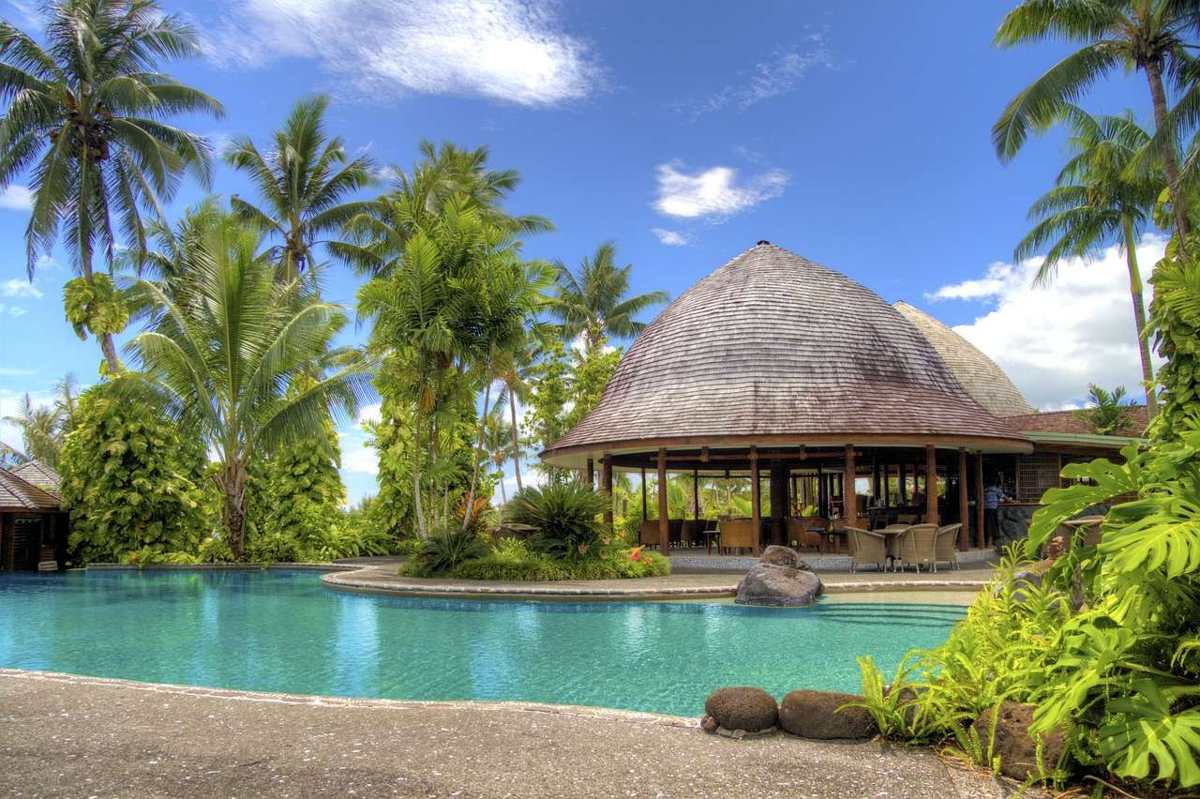 The 20-metre pool framed by palms and thatched roofs